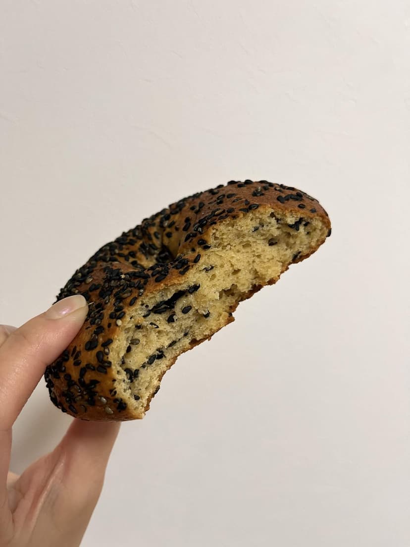 The black sesame bagel cut open, showing the dense crumb with sesame throughout