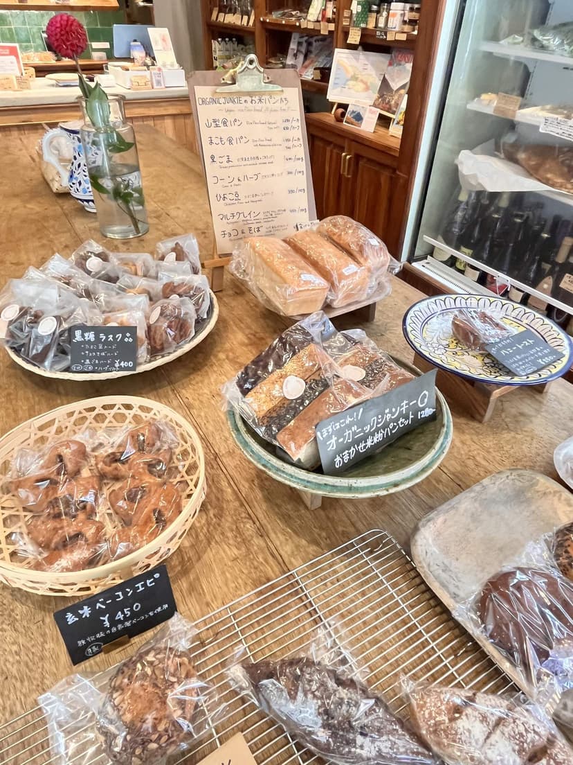The shop interior: bread on wooden boards and cooling racks, with a handwritten menu board at the back