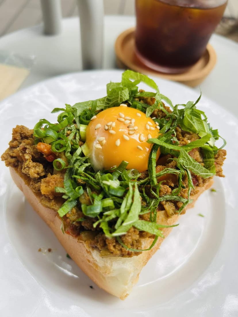 The spice keema curry toast with herbs and egg yolk