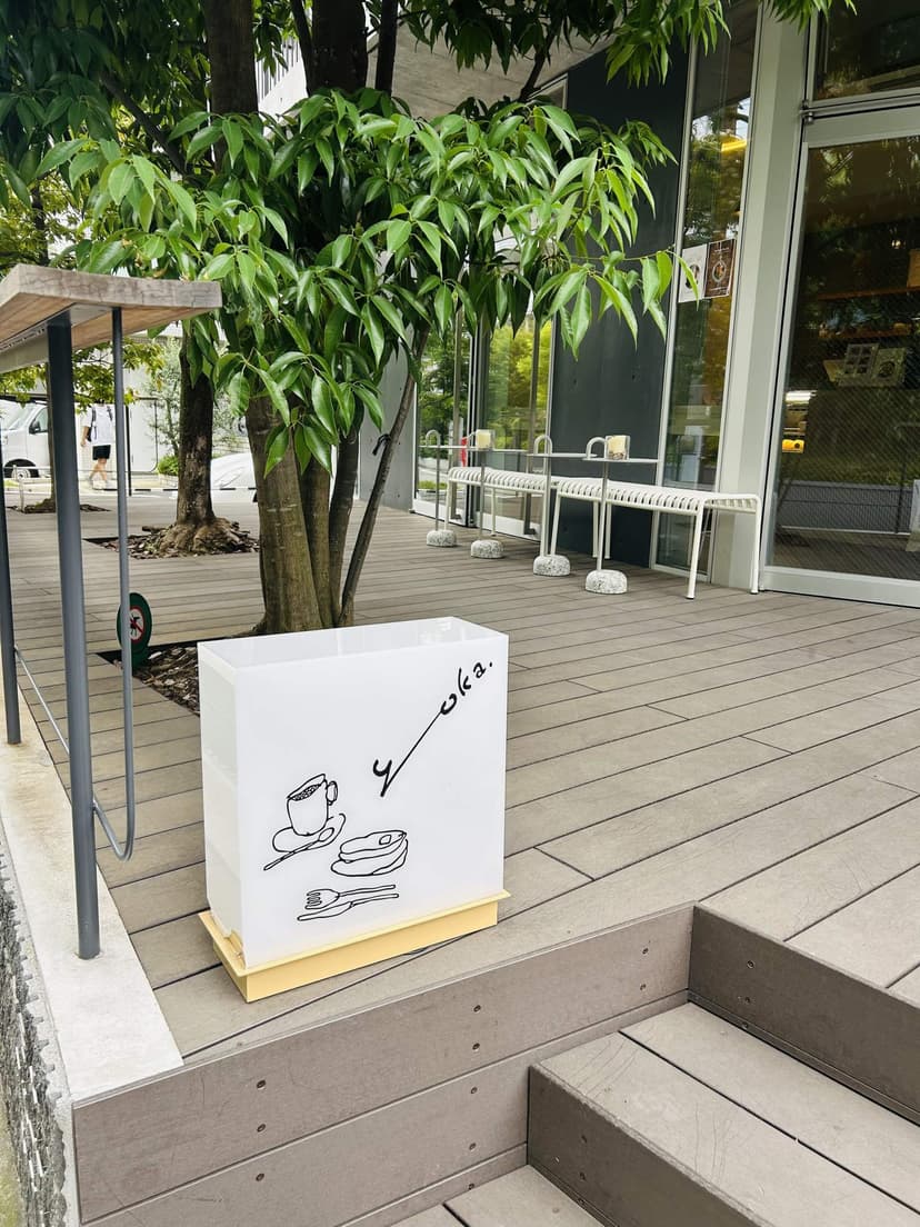 The entrance of yoka, with its hand-drawn sign under a big tree
